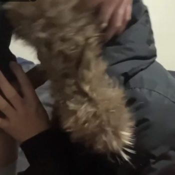 Woman in a black puffer jacket with a big beige fur hood giving a blowjob indoors, furhood jacket porn